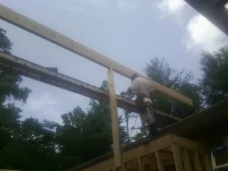 Carpenter setting a ridge beam over a new addition frame — Ice Dam Removal by Roofing Brothers in Arkville