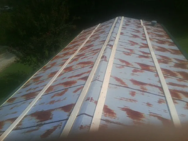 Rusted metal roof panels with new wood purlins before replacement — Storm Damage Roof Repair in Arkville by Roofing Brothers
