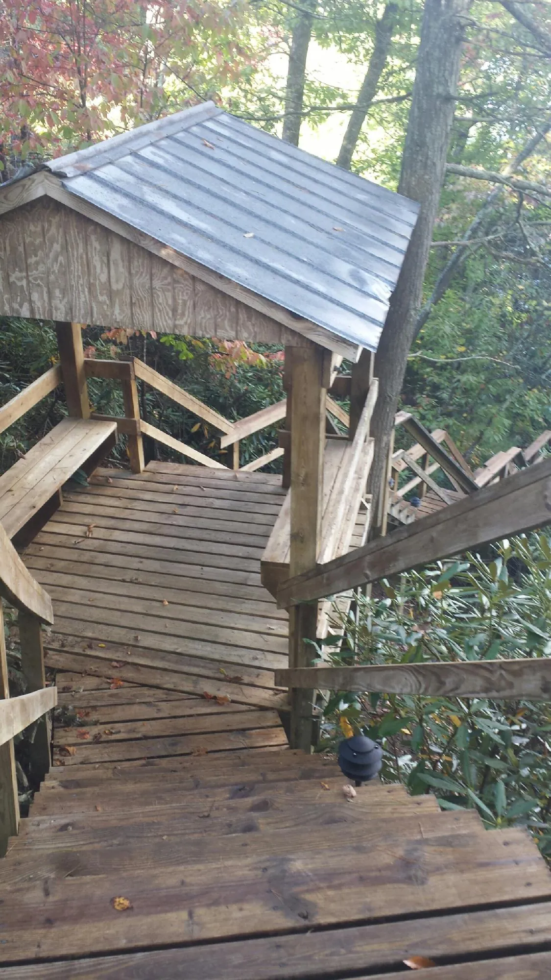 Metal roofed shelter over wooden steps on a wooded walkway — Skylight Repair & Installation work by our crew in Arkville